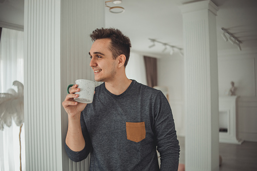 Portrait of a young man in his new home drinking his morning coffee