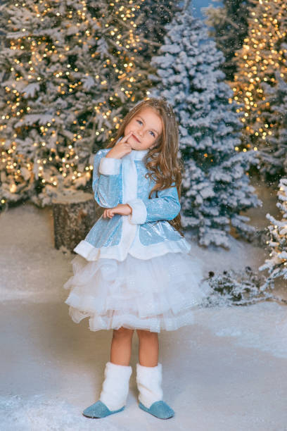 linda chica rubia caucásica caminando por el bosque navideño de invierno con luces. año nuevo, concepto de cuento de hadas - ice maiden fotografías e imágenes de stock