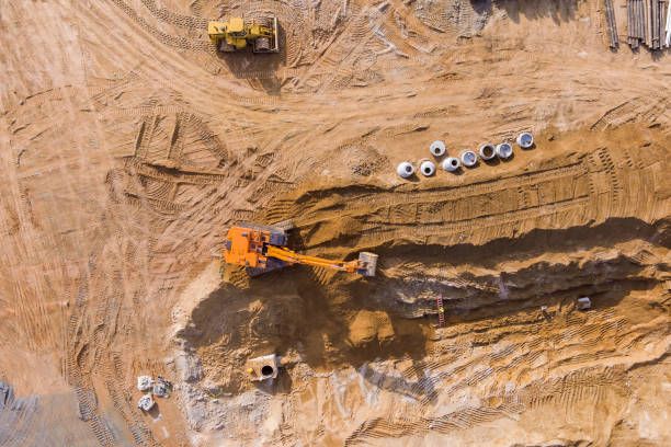 istock Excavators are digging trenches for sewer laying and connecting underground storm sewer pipes to a sewer system at a construction site on a sunny day. 1434526056
