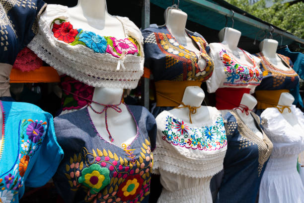 mexican embroidered dresses on street market stall - mexico dress market clothing imagens e fotografias de stock