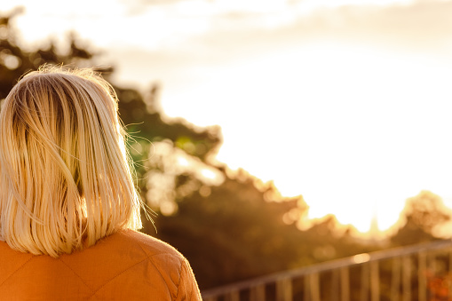 Rear view of a blond hair woman watching sunset