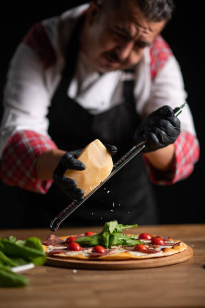 istock A male chef grating cheese on a pizza 1434540356