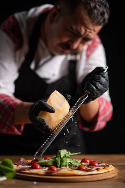istock A male chef grating cheese on a pizza 1434540384