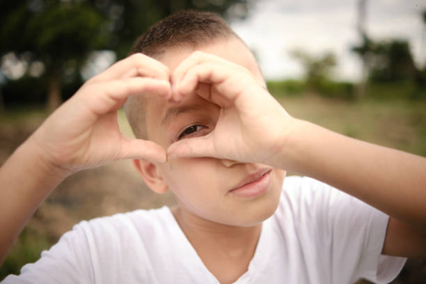istock latino child looking at camera through heart sign made with hands 1434541283