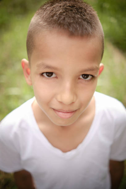 Young boy with blonde hair and blue eyes looking up showing a thoughtful expression