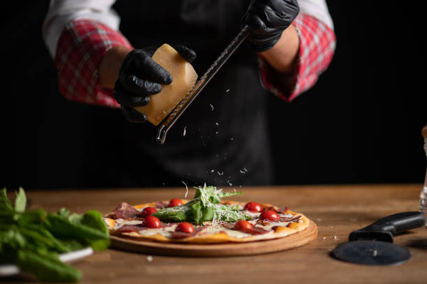 istock A male chef grating cheese on a pizza 1434541494