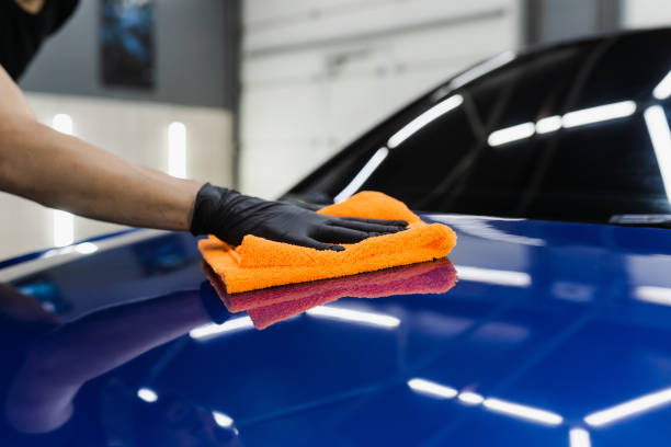 istock Hand car drying with microfiber in detailing auto service. Cleaner worker dry body car after washing automobile. 1434542379