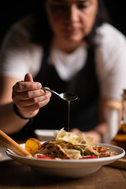 istock A female chef pouring sauce on salad 1434542388