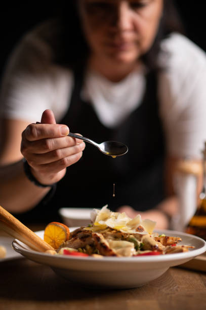 istock A female chef pouring sauce on salad 1434542418