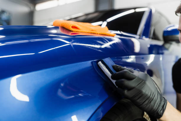 istock Process of applying ceramic protective coat on body car using sponge in detailing auto service. Car service worker apply ceramic coating to protect the car body from scratches. 1434542461