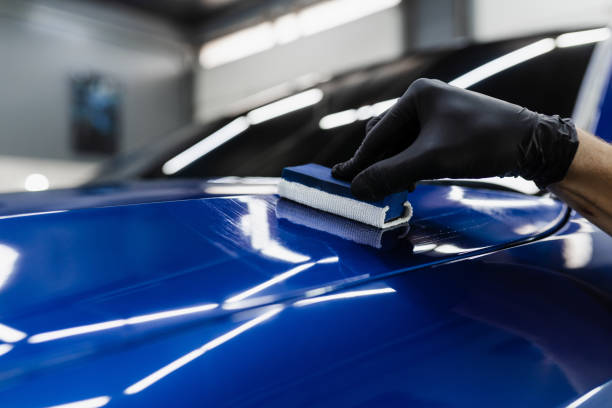 istock Process of applying ceramic protective coat on body car in detailing auto service. Car service worker apply ceramic coating to protect the car body from scratches. 1434542502
