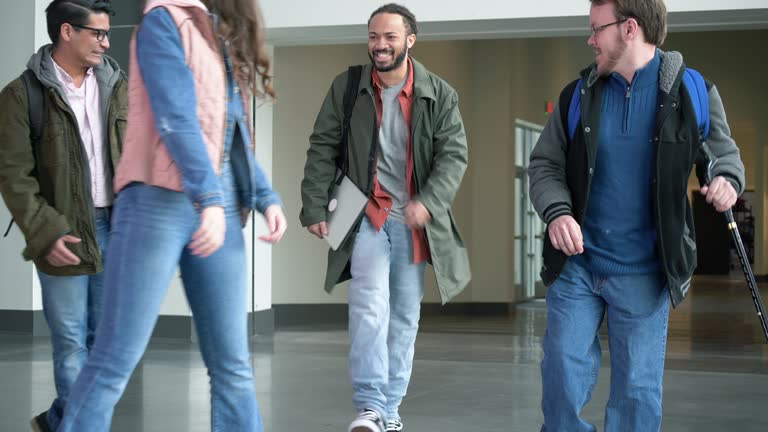 College student using cane, friends walk in school building