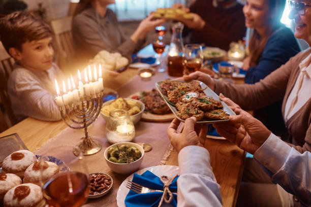 close up of jewish family having a meal together at dining table on hanukkah. - latke imagens e fotografias de stock