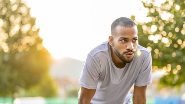 istock Young handsome man bending, breathing deeply after jogging 1434556487