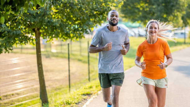 istock Smiling young couple jogging outdoors together, medium shot 1434556491
