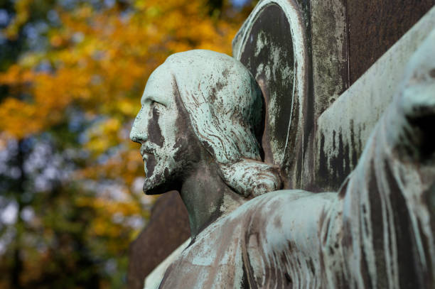 scultura di gesù in un cimitero d'autunno - jesus christ cross old statue foto e immagini stock