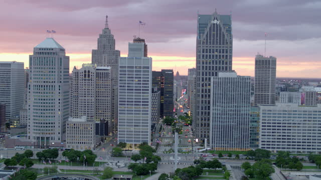 Aerial Footage of dolly left across multiple buildings during sunset in downtown Detroit