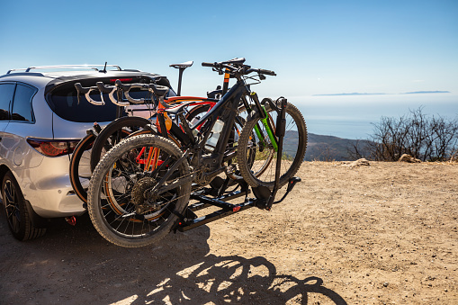 A car parked at a turnout in the Santa Monica Mountains in Malibu, California with four bicycles mounted on the back.