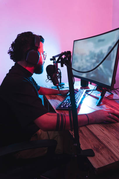 istock Professional hispanic gamer with headphones and a microphone playing a online game. 1434565731