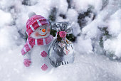 istock Happy snowman holds a bag with Christmas presents in winter snowy forest 1434568728