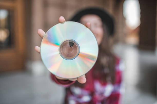 A close-up shot of a CD showing its shiny surface with vibrant multicolor reflections.