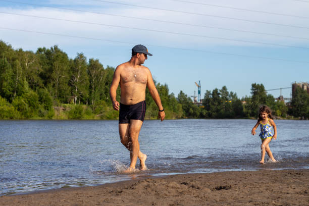 istock Dad and daughter running on the beach 1434587222