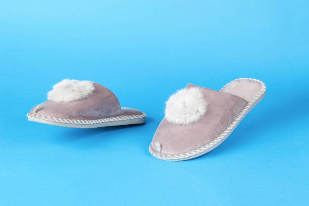 istock Beige slippers running on a blue background. 1434588727