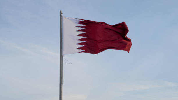 флаг катара развевается высоко на ветру.. - qatari flag стоковые фото и изображения