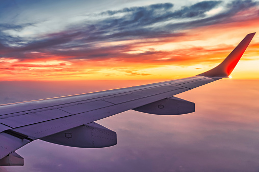 The airliner flies at sunset