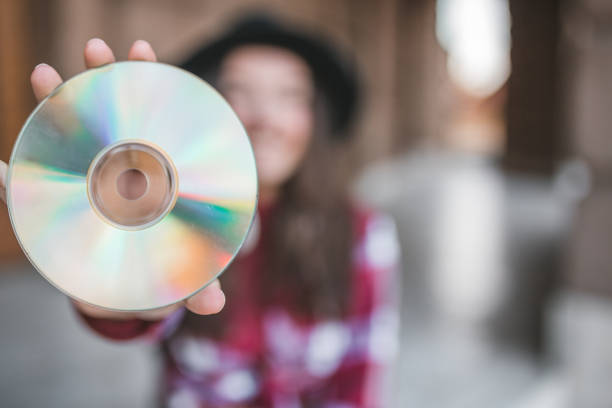A young woman is enjoying a beautiful day while listening to music with a disc player