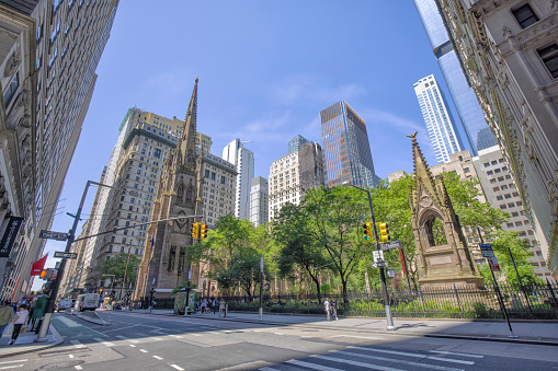 Street view of New York City Lower Manhattan intersection,  Trinity Church in the background.