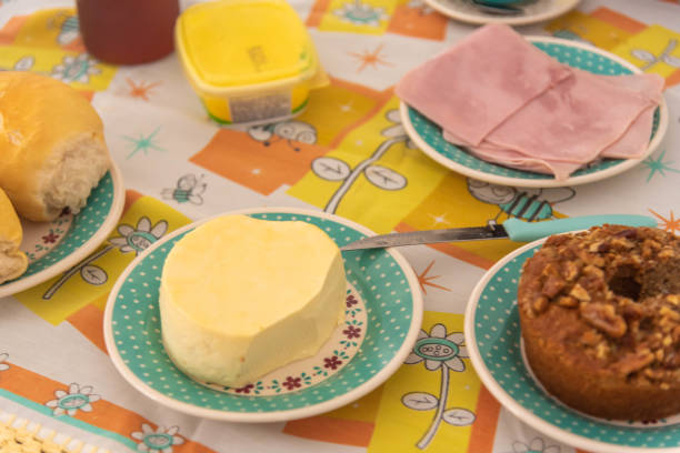 Table with coffee, bread, cheese and cake with nuts.