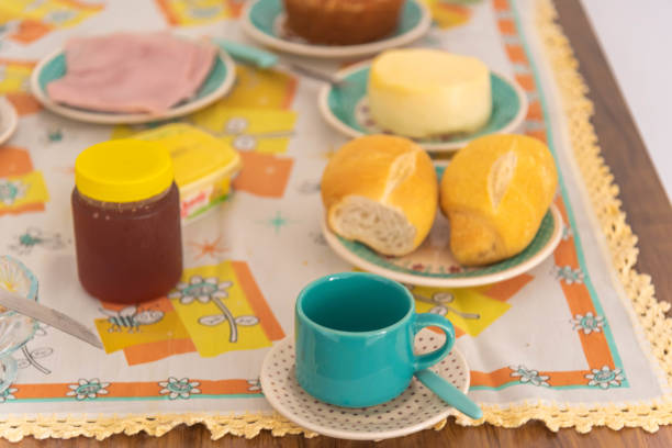 Table with coffee, bread, cheese and cake with nuts.