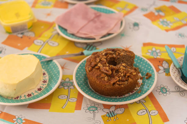 Table with coffee, bread, cheese and cake with nuts.