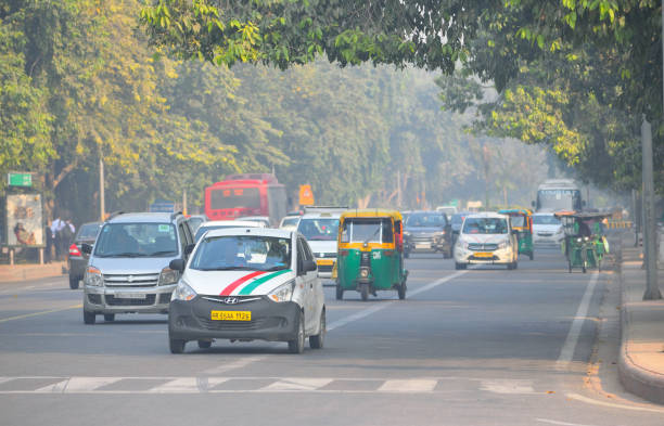 Vehicles running along the road in New Delhi covered in smog. Delhi, India - November 21, 2017: Vehicles running along the road in New Delhi covered in smog. mode of transport
