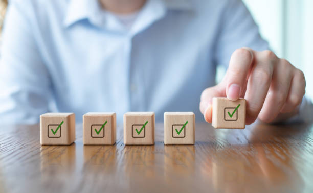 istock Checklist, Task list, Survey and assessment, Quality Control, Goals achievement and business success. Vote, to do list, Hand holding green check mark on wooden block to complete checklist. 1434616679