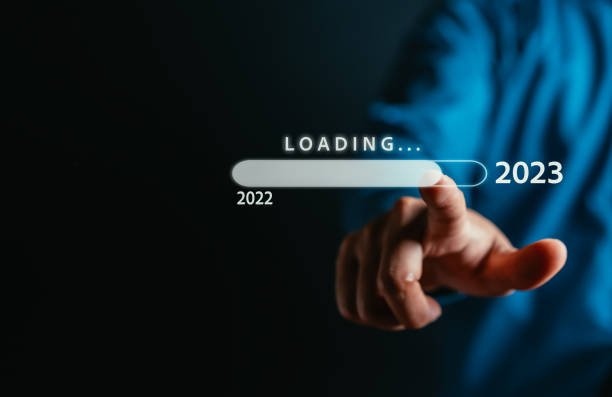 hombre de negocios tocando la barra de descarga virtual y cargando para año nuevo y cambiando el año 2022 a 2023. iniciar el negocio de planificación en el concepto de los próximos años. - descargar actividad fotografías e imágenes de stock