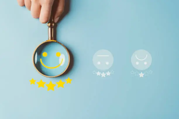Photo of Excellent rating User give rating feedback, Magnifier glass focus to Smiley face five stars icon which is among rating service for satisfaction evaluation survey and review. good business network score.