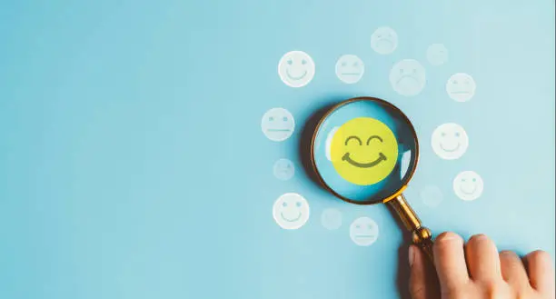 Photo of Excellent rating User give rating feedback, Magnifier glass focus to Smiley face icon which is among rating service for satisfaction evaluation survey and review. good business network score.