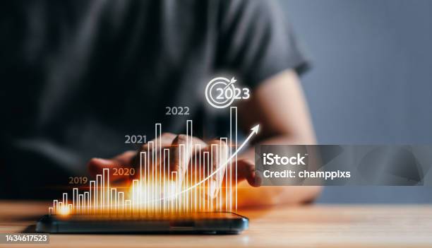 Businessman Analyzes Profitability Of Working Company With Digital Virtual Screen Graphics 2023 Planning Invest Indicators Longterm Positive Of Businessman Calculates Financial Data Investments Stock Photo - Download Image Now