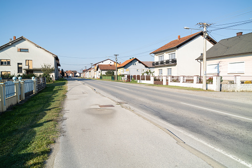 Street with road and houses in Croatian village. Rural landscape in the morning.