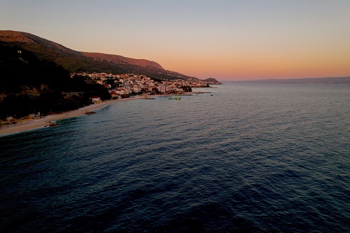 An aerial of the beautiful seascape and a coastal town at sunset captured in Podstrana, Croatia