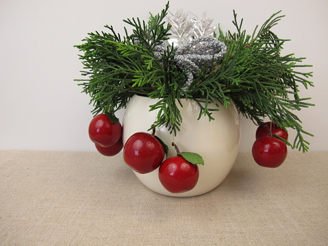 Small handmade christmas arrangement with thuja and decoration in a vase