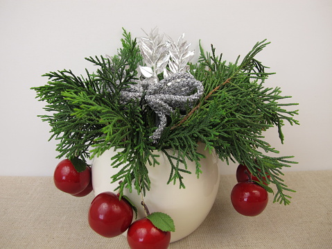 Small handmade christmas arrangement with thuja and decoration in a vase