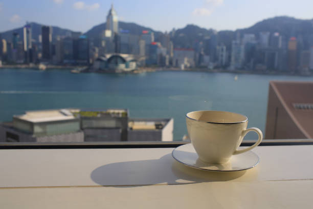 Victoria harbour hong kong island skyline with paper note and coffee cup stock photo