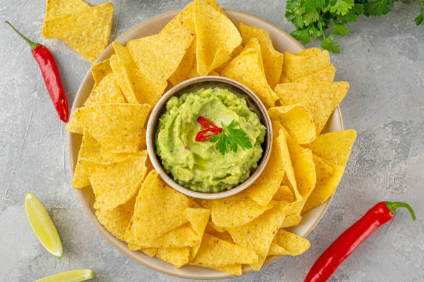 istock Mexican Nachos chips and dip sauces. Tortilla corn nachos chips with tomatoes salsa and guacamole. Top view. 1434629167