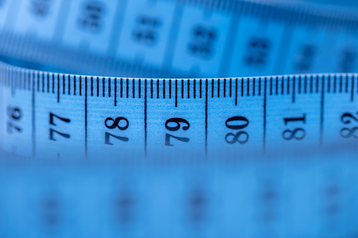 Close-up of a blue tape measure. Shallow depth of field, space for copy.