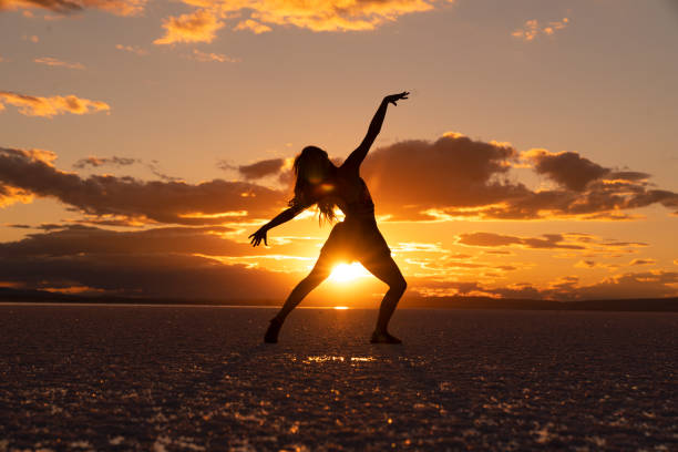 Beautiful ballerina dancing at sunset on a gorgeous salt lake. stock photo