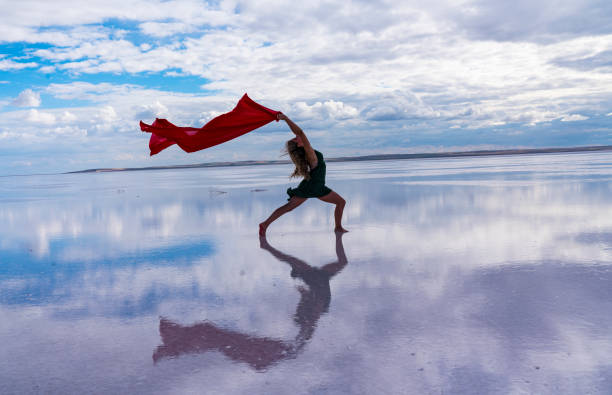 Beautiful modern ballet dancer dancing on the lake with tulle