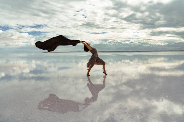 Beautiful modern ballet dancer dancing on the lake with tulle